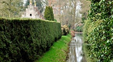 Rivier en struiken met gebouw erachter